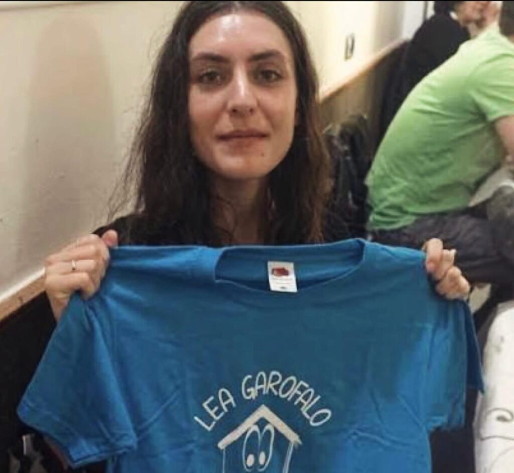 Foto di Denise che tiene in mano una maglietta blu con scritto il nome della madre Lea Garofalo